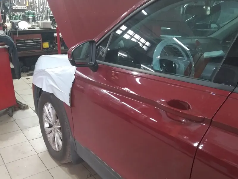 Volkswagen Tiguan у боксі, крило вкрите чохлом